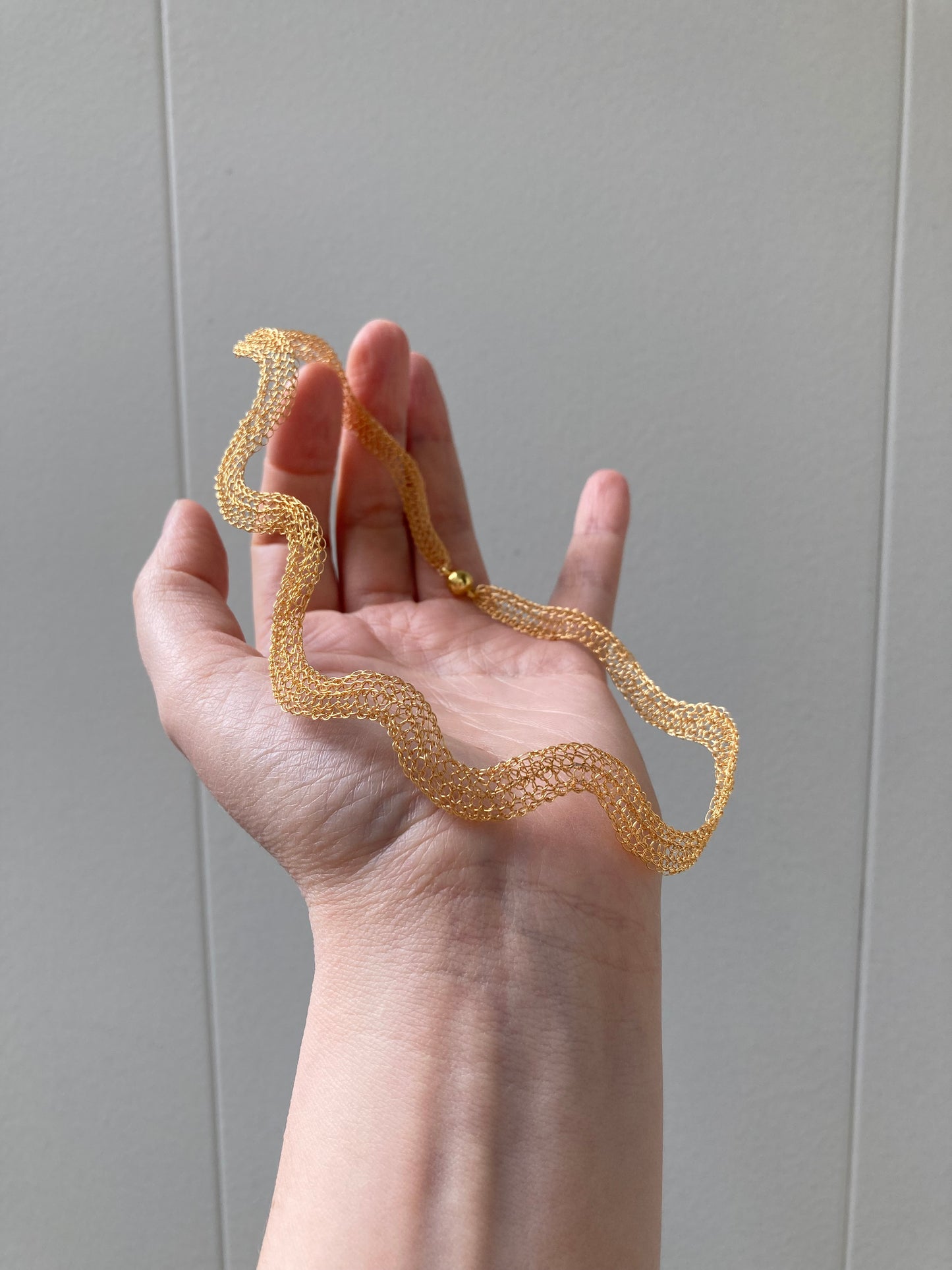 Gold asymmetrical wave choker